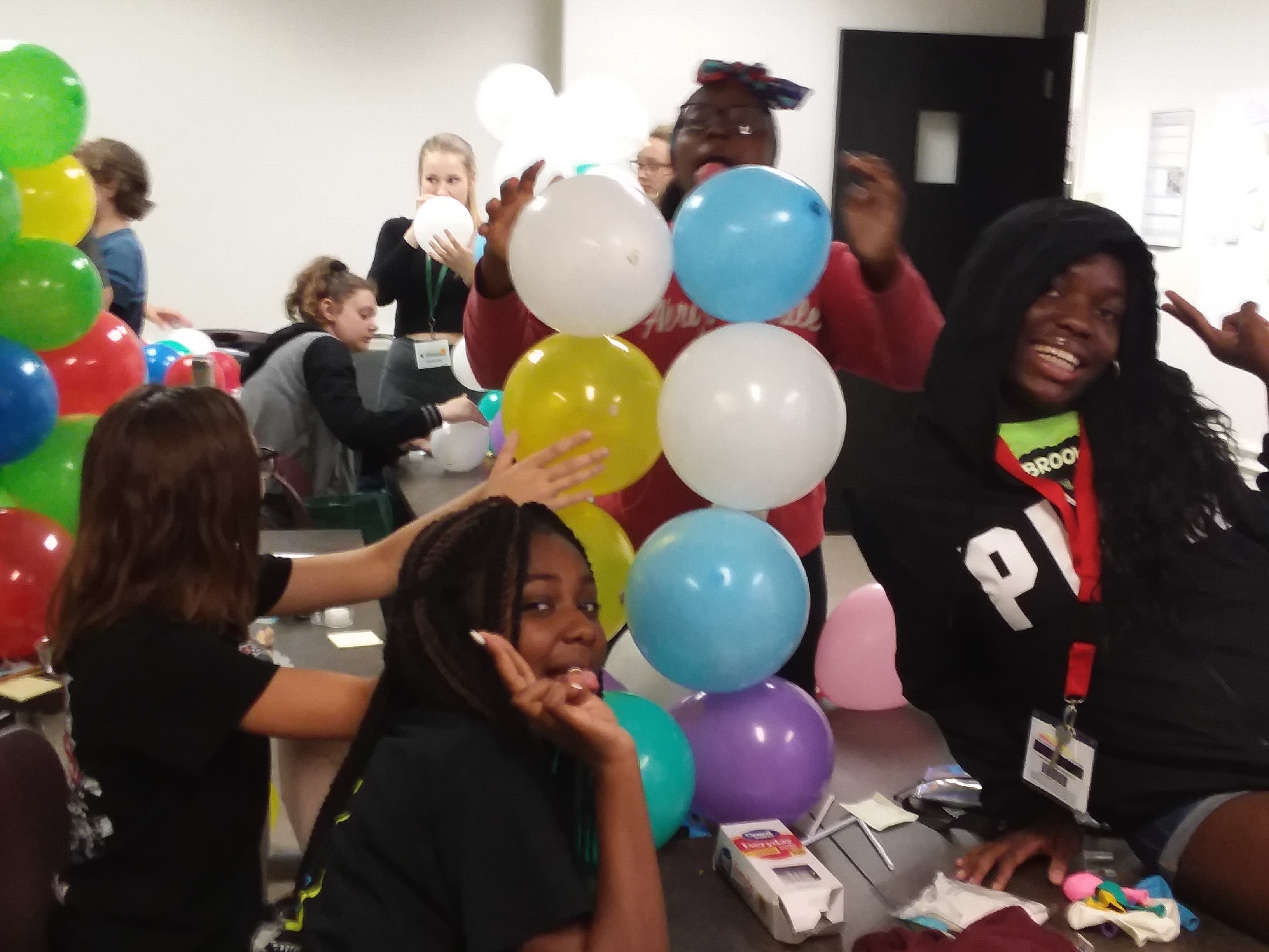 Youth next to a tower of balloons.